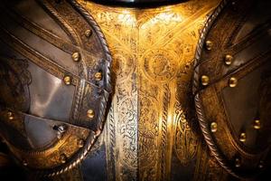Antique armour on black background. Concept for security, safety and fantasy. photo