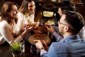 Young people having dinner in the restaurant photo