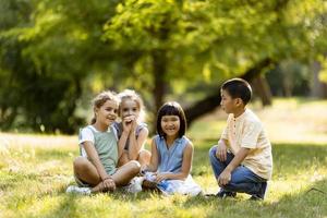 grupo de niños asiáticos y caucásicos divirtiéndose en el parque foto