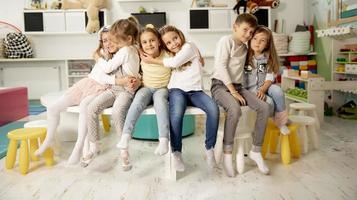 Group of kindergarten kid friends sitting and having fun photo