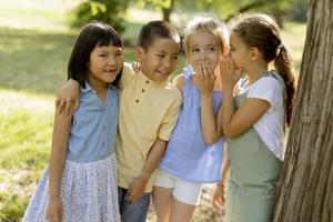 grupo de niños asiáticos y caucásicos divirtiéndose en el parque foto