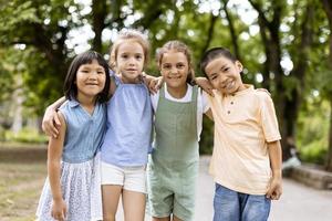 grupo de niños asiáticos y caucásicos divirtiéndose en el parque foto