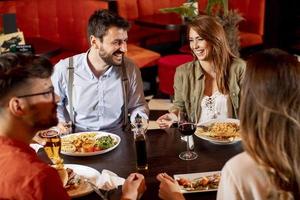 Young people having dinner in the restaurant photo