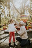 abuelo divirtiéndose con su nieta en el parque de atracciones foto