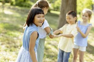 grupo de niños asiáticos y caucásicos divirtiéndose en el parque foto