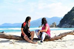 friends relaxing and talking on the beach photo