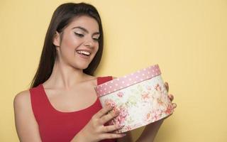 Portrait of a happy smiling girl opening a gift box photo