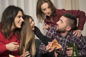 Friends having fun at home eating pizza drinking beer and leafing. Friends having fun concept photo