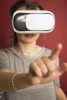 Pretty cute excited female in VR headset looking up and trying to touch objects in virtual reality photo