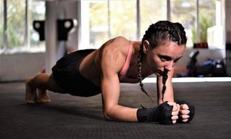 Woman on boxing training doing push ups photo