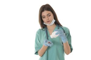 Portrait of professional female smiling doctor in green scrubs holding a brown pill bottle Medical Care photo