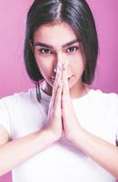 Young woman holding hands in pray near mouth, feels confident photo