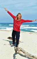 hombre balanceándose en un tronco en la playa foto