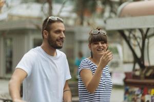 un par de turistas divirtiéndose caminando por las calles de la ciudad en vacaciones - amigos felices riéndose juntos en vacaciones - concepto de personas y vacaciones foto