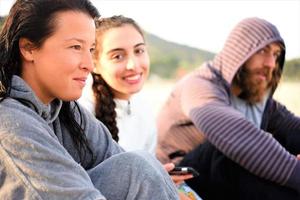 friends relaxing on the beach and talking photo