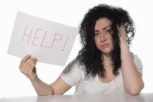 young attractive frustrated and tired businesswoman holding help sign message overworked at office computer, exhausted, sad under pressure and stress isolated on white photo