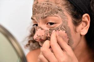 Beautiful woman having clay facial photo