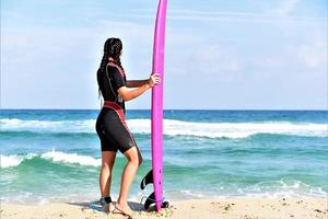 Beautiful sexy surfer girl on the beach photo