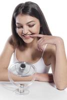 Portrait of a girl putting cosmetic ointment on face while watching at mirror indoor photo