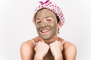 Beautiful woman removing clay facial mask from her face photo