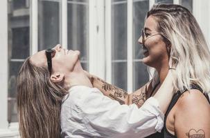 un par de mujeres gay sonriendo y besándose. pareja de mujeres jóvenes casadas del mismo sexo en su rutina diaria mostrando algo de afecto lgbt foto