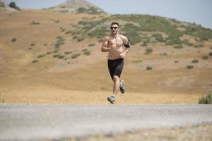 corredor de hombre deportivo corriendo en la meseta de la montaña en verano foto