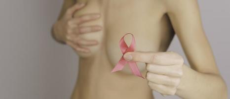 Woman hold pink ribbon in hand. fight breast cancer, message for female photo