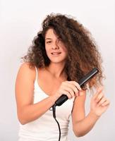 wavy-haired girl ironing straightening messy curls keratin therapy treatment photo