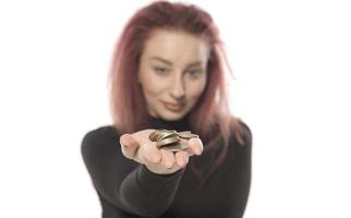 mujer dejando caer monedas en su mano. aislado sobre fondo blanco foto