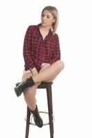 Smiling young woman sitting on stool. Isolated studio portrait on white back. photo