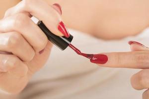 Beautiful manicure process. Nail polish being applied to hand photo