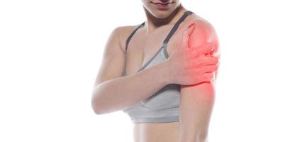 mujer con dolor de hombro. inflamación aguda en el hombro de una mujer. foto conceptual con punto de lectura que indica la ubicación del dolor.