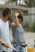 retrato de una alegre pareja joven caucásica hombre y mujer sosteniendo muchas bolsas de papel después de ir de compras mientras camina y habla en la calle. feliz pareja familiar con paquetes al aire libre. concepto de compra foto