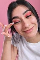 Woman doing make up, looking at mirror. photo