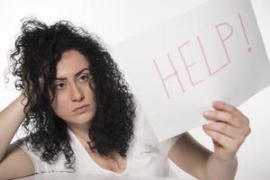 young attractive frustrated and tired businesswoman holding help sign message overworked at office computer, exhausted, sad under pressure and stress isolated on white photo