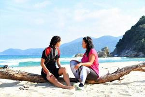 amigos relajándose y hablando en la playa foto