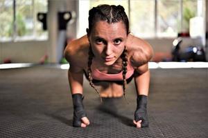 mujer en entrenamiento de boxeo haciendo flexiones foto