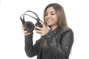 Beautiful modern girl singing favorite song, listening to music in wireless headphones, smiling and dancing photo