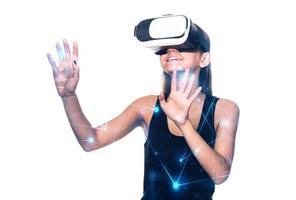 linda mujer emocionada con auriculares vr mirando hacia arriba y tratando de tocar objetos en la realidad virtual foto