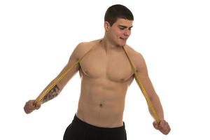 male model with great body measuring his body with measuring tape photo