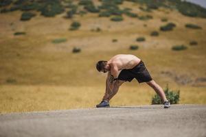 Young man runner running on a mountain road. Jogger training workout in fitness shoe. Healthy lifestyle and sport concept.  Motion blur and selective focus. photo