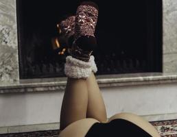 Feet in woolen socks by the Christmas fireplace. photo