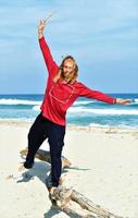 hombre balanceándose en un tronco en la playa foto