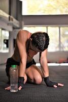 female fighter drinking water and resting after the training. photo