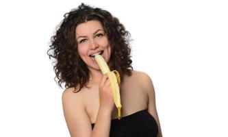 mujer joven comiendo plátano. foto