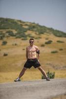 Young man runner running on a mountain road. Jogger training workout in fitness shoe. Healthy lifestyle and sport concept.  Motion blur and selective focus. photo