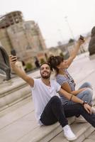 Couple of tourists having fun walking on city street at holiday - Happy friends laughing together on vacation - People and holidays concept photo