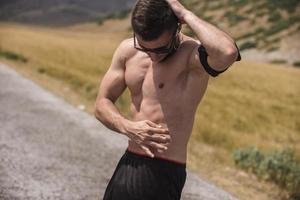 Athletic young man stretching after run in the nature. sport concept photo