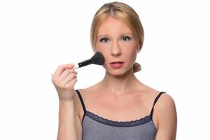 beautiful young smiling woman apply makeup with brush. isolated photo