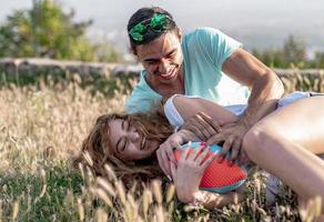 pareja jugando fútbol americano en un caluroso día de verano. sesión de fotos de pareja jugando al rugby